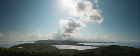 View across a lagoon towards El Yunque across with the distant rain falling on the rain forestの写真素材