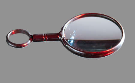antique brass magnifying glass isolated against greyの写真素材