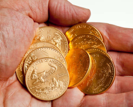 Gold Eagle one ounce coins in a stack in the palm of a handの写真素材