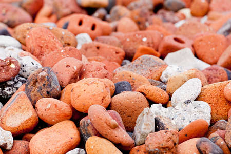 Sea worn pebbles and bricks form a sea wall on beachの写真素材