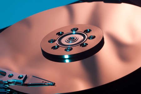 Magnetic disc inside a computer hd unit showing mirror surface of the magnetic discs and read write headの写真素材