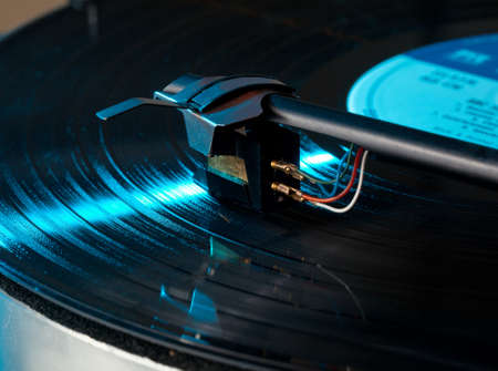 Old record player with focus on the cartridge and stylus on LPの写真素材