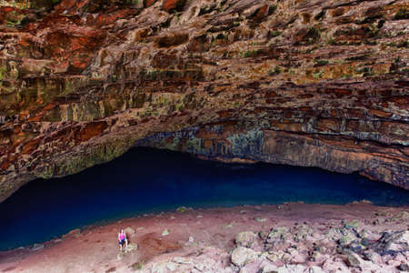 Waikapalae wet cave with female hiker in Kauai. Cave used in Pirates of Caribbean