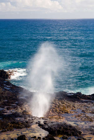 Vent of water from underneath lava rocks on coast of Kauaiの写真素材