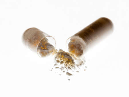 White medicine powder from capsule emptied onto isolated white backgroundの写真素材