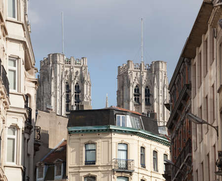 Towers of Cathedral of St Micheal in Brussels over top of local homes and roofsの写真素材