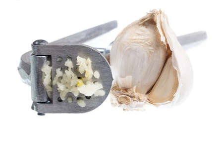 Garlic press and garlic isolated against white in macro shotの写真素材