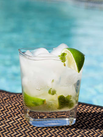 Glass of ice cold majito in glass by side of swimming poolの写真素材
