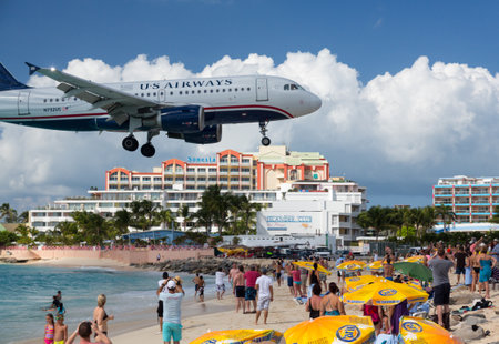 PRINCESS JULIANA AIRPORT, ST MARTIN -  NOVEMBER 1: US Airways flight lands over Maho beach on November 1, 2012. The 2300m runway is approached over the sea.のeditorial素材