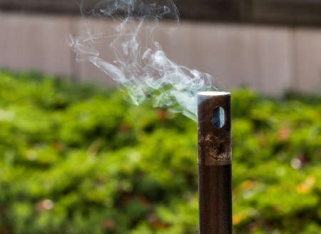 Smoke from cigarettes still burning in waste disposal unitの写真素材