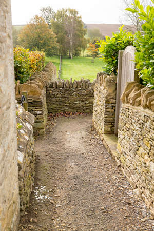 Narrow footpath between stone walls from Swinbrook to Widford in Windrush Valleyの写真素材