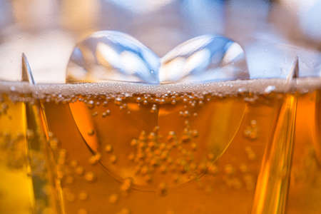 Detail of a cut glass champagne goblet with a heart on the side and filled with drinkの写真素材