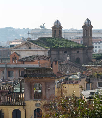 Basilica church with grass on roof in the skyline of Rome Italy with smog in the distanceの写真素材