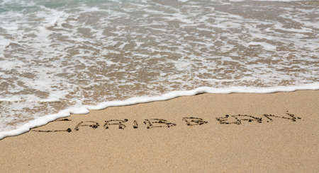 Caribbean words written into sand on beach by sea in St Thomasの写真素材