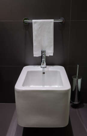 Details of modern square bidet in black tiled bathroomの写真素材