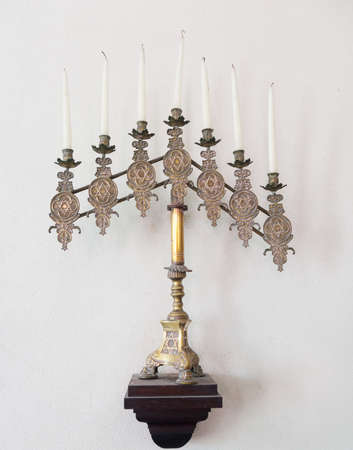 Antique ornate menorah in brass with old tallow candles