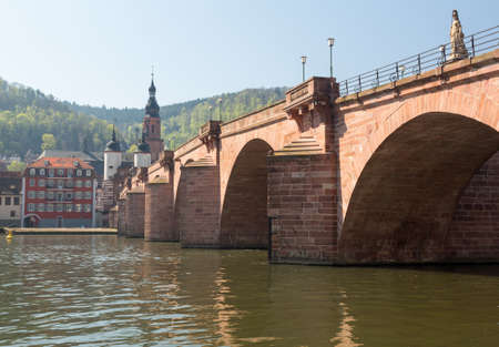 Medieval bridge leading into old town of Heidelberg Germany from riverbank of River Neckarの写真素材