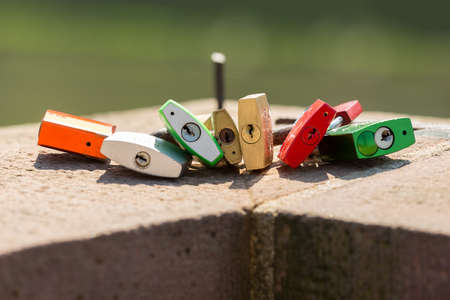 Padlocks and locks fastened to old bridge leading into town city of Heidelberg Germany by local...