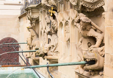 Statue from fountain at Schwabisch Hall, Germany. Dating from 1509, the fountain stands against a decorative wall adorned with statues of Samson, St Michael and St George. The rectangular design, unusual in a Gothic fountain, includes the old pillory postの写真素材