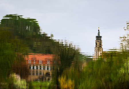 Evangelical Lutheran church of St Johannis or Johannes in small Bavarian village of Castell in Germany. Church and castle or schloss is reflected in the rippled water of the village pondの写真素材