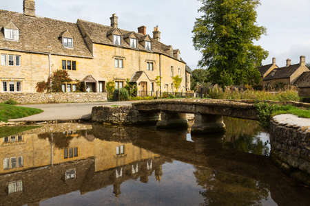 Lower Slaughter with river in Cotswold or Cotswolds district of southern England in the autumn.の写真素材