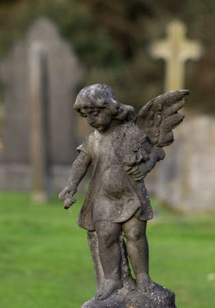 Statue of angel above grave of dead girl in old cemetery in Shropshire in Englandの写真素材