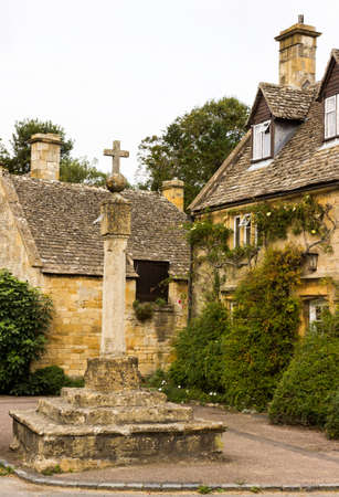 Town square with cross in Stanton in Cotswold or Cotswolds district of southern England in the autumn.の写真素材