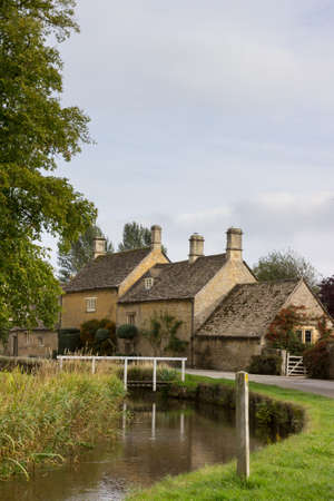 Lower Slaughter with river in Cotswold or Cotswolds district of southern England in the autumn.の写真素材