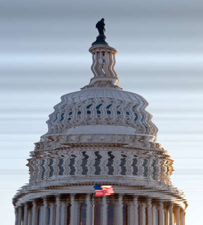 US flag flies in front of the US Capitol in Washington DC in submerged distorted view of the dome of Congress buildingの写真素材