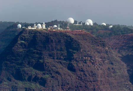 Naval base on top of rugged mountains and cliffs of Na Pali coast in Kauai seen from a cruise boat in winterの写真素材