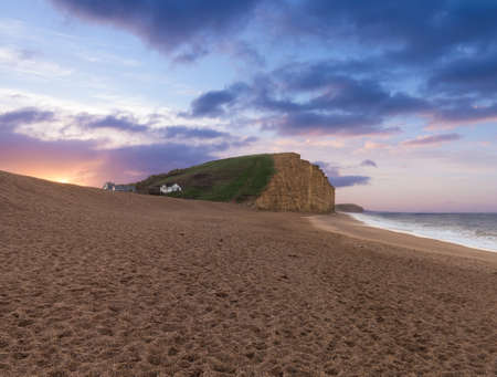 Sunrise on the beach underneath the cliffs and headland at West Bay in Dorset. This was used as the location for the Broadchurch TV seriesの写真素材