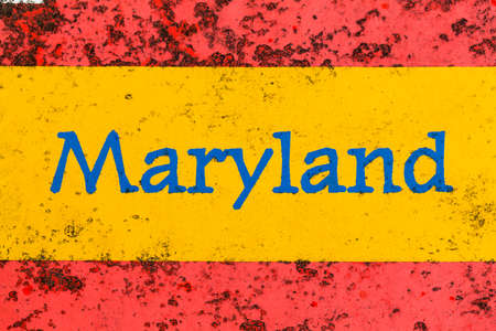 Detail of the word Maryland on a newspaper stand that is brightly painted but starting to rustの写真素材