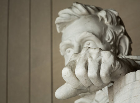 Focus on the clenched fist of the statue of President Lincoln as he stares at the audience showing the strength of his personality and conviction of his ideasのeditorial素材