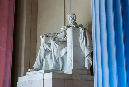 Red and blue pillars illuminate the white statue of President Lincoln in Lincoln Memorial in Washington DC in illustration of US flagのeditorial素材