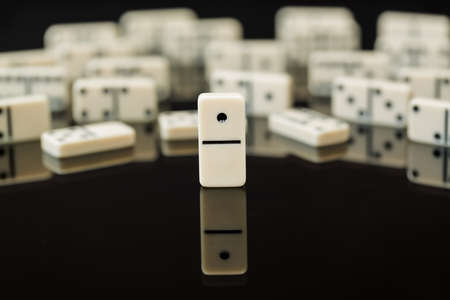 Number One domino in front of peers as concept image for success, innovation, leadership, winning and leader of the packの写真素材