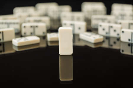 Single blank domino in front of peers as concept image for being different, blank slate, open to change, flexible, malleableの写真素材
