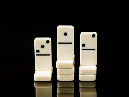 Concept image of three dominoes set up in traditional race winner stand of first, second, third showing success, innovation, leadership, winning and leader of the packの写真素材
