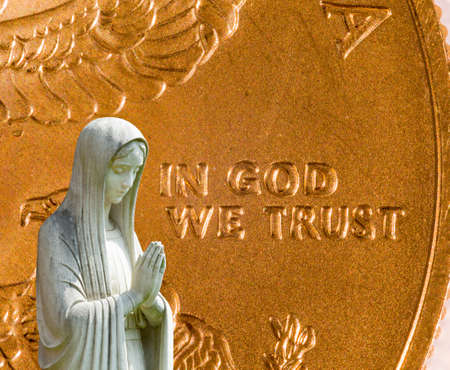 Image of statue of lady praying with US currency as background as a concept for the linkage of religion with money and wealthの写真素材