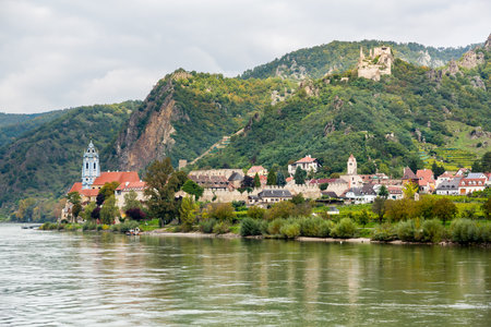 Ornate church and buildings on banks of River Danube in Durnstein, Austriaのeditorial素材