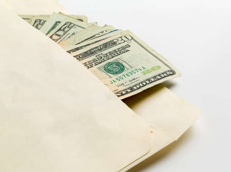 Stack of used $20 US currency bills or notes in an envelope in a concept photo for a bribe or paymentの写真素材