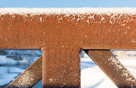 Abstract pattern of rusty framework and structure of pedestrian bridge in snow in winterの写真素材