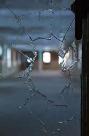 Scary image of broken glass in shards leading into an empty room in old hospitalの写真素材