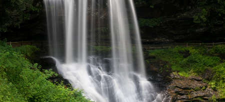 Panoramic view of Dry Falls waterfall cascading down the rocks on Mountain Water Scenic Byway near Highlands in North Carolina, USAの写真素材