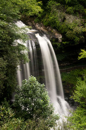 Dry Falls waterfall with blurred motion cascading down the rocks on Mountain Water Scenic Byway near Highlands in North Carolina, USAの写真素材