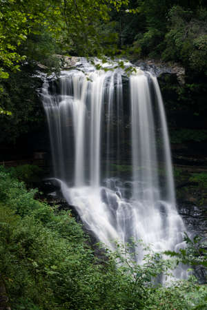Dry Falls waterfall with blurred motion cascading down the rocks on Mountain Water Scenic Byway near Highlands in North Carolina, USAの写真素材