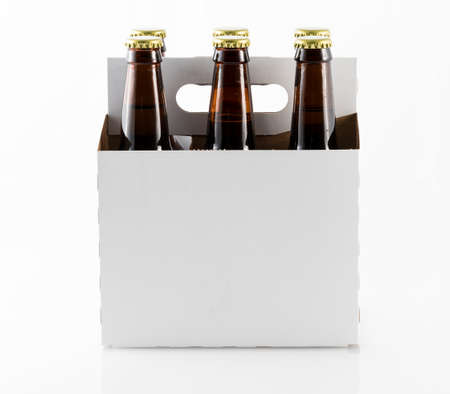 Six beer bottles in cardboard container with gold caps with side of carrier facing cameraの写真素材