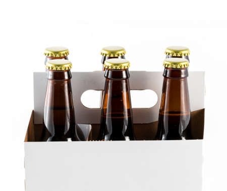Six beer bottles in cardboard container with gold caps with side of carrier facing cameraの写真素材