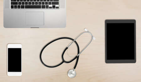 Clean and tidy wooden desk with equipment ready for medical doctor using latest technology instead of paper recordsの写真素材