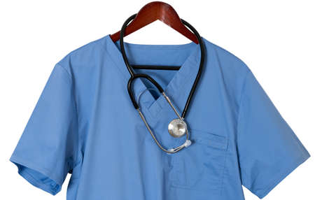 Blue medical scrubs uniform shirt hanging on a hanger with stethoscope with path and isolated...