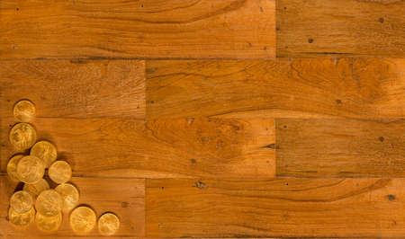Wooden background of table with gold eagle coins in the corner to make a design for website with copy spaceの写真素材